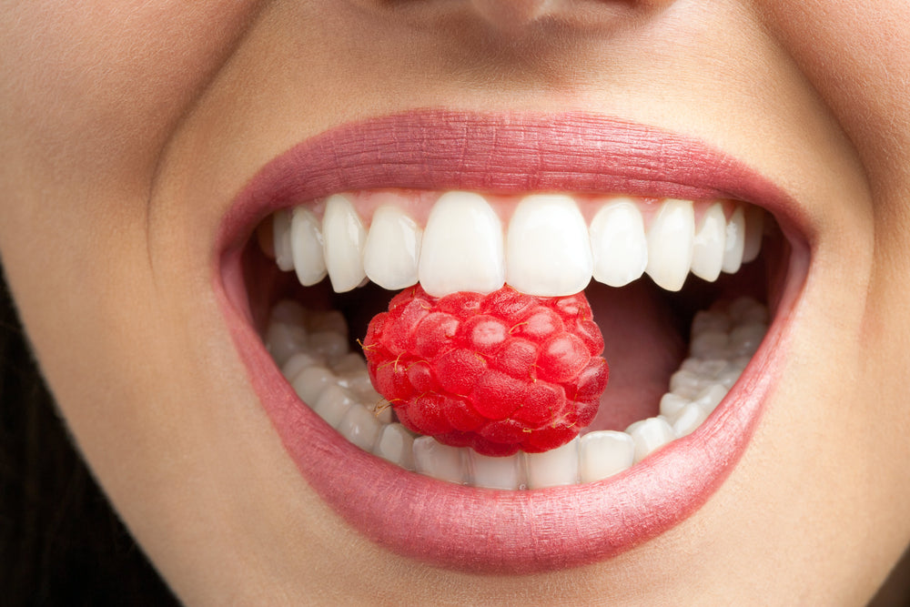 Woman with raspberry in her mouth