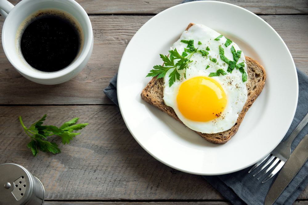 A sunny-side up egg on top of a piece of toast, and a cup of coffee. A.