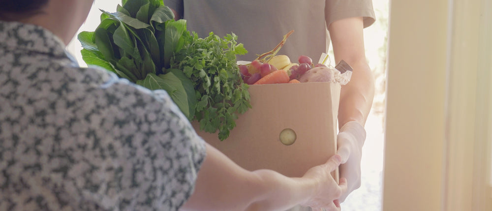 Volunteer handing out a box of food