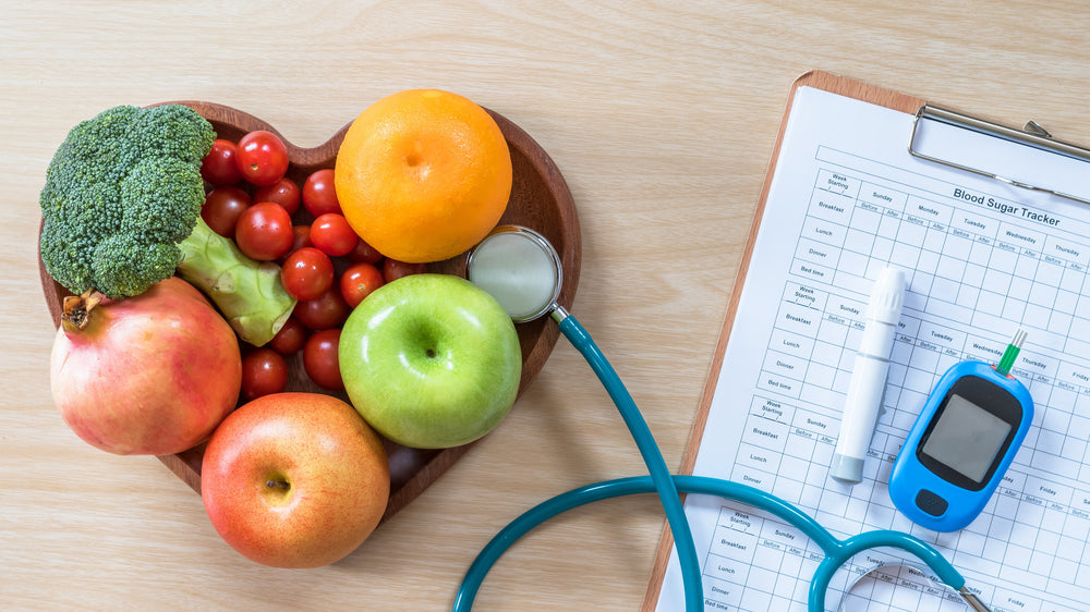 A bowl of fruit next to a stethoscope and health chart. A
